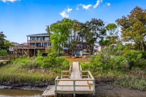 Waterfront Oak Island Home with Dock في أوك آيلاند: منزل على نهر مع رصيف ومنزل