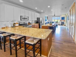 a kitchen with a large island with bar stools at 5410 Cross Country Mountain Ski Getaway with Hot Tub Pool! by SkyRun Park City in Park City