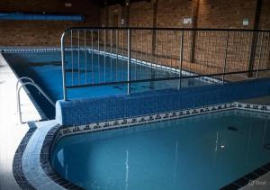 a large swimming pool with a metal fence around it at Cambrian Rio Caravan in Ynys-lâs Station