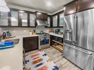 een keuken met houten kasten en een roestvrijstalen koelkast bij Blackstone 106 by SkyRun Park City in Park City