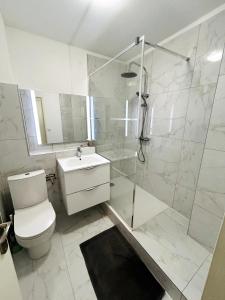 a bathroom with a shower and a toilet and a sink at Appartement au coeur de la Grande Motte, vue mer in La Grande-Motte