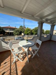Una mesa blanca y dos sillas en un patio. en Federica's House, en Olbia