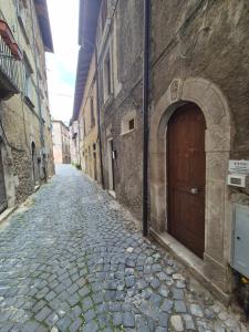a stone alley with a wooden door on a building at Vico al 23, in pieno centro storico in Tagliacozzo