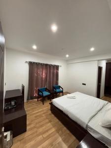 a bedroom with a bed and two chairs in it at BARCHA Guest house in Leh