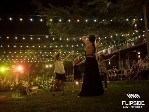 a group of people standing in the grass with lights at Villa Xiav - Flipside Adventures in Bản Kin