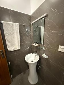 a bathroom with a sink and a mirror at Royal Elite Hotel Kalam in Kalām
