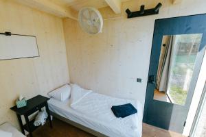 a small bedroom with a bed and a window at TRESKI Ö-majakesed in Treski