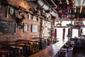 un bar avec des tables et des chaises en bois et un mur en briques dans l'établissement Chic Condo Retreat Private Bliss n Birmingham, à Birmingham