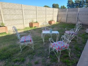 Un grupo de sillas y una mesa en un patio. en Departamentos TUNQUELEN, en Río Colorado 5 fotos más