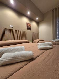 a room with three beds with towels on them at Il Fiore di San Giovanni B&B in Milazzo