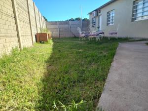 Un patio con sillas y una cerca y un edificio. en Departamentos TUNQUELEN, en Río Colorado