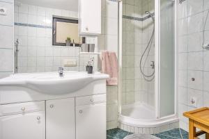 a white bathroom with a sink and a shower at Resort pod orehi - Bled - Apartma & Glamping & Savna in Bled