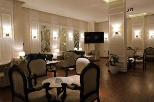 a hotel lobby with chairs and tables and a television at جولدن هافن Golden Haven in Ahad Rafidah