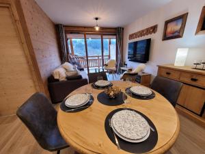 ein Esszimmer mit einem Holztisch und Stühlen in der Unterkunft Appartement 4* avec 2 suites, balcon, garage, accès rapide aux pistes, WiFi - FR-1-598-139 in Les Gets