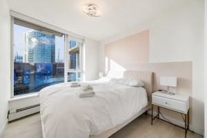 Ένα ή περισσότερα κρεβάτια σε δωμάτιο στο Bright 3BR Downtown Vancouver Condo w Pool & Gym +7 φωτογραφίες