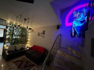 a living room with a cat mural on the wall at Gato Neon Hostel in Bogotá