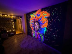 a painting of a woman on a wall in a room at Gato Neon Hostel in Bogotá