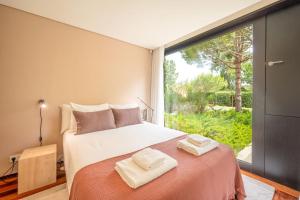 una camera da letto con un letto e una grande finestra di Stunning Tróia II by LovelyStay a Tróia