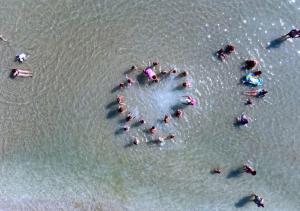 a group of people standing in the water at the beach at FAMILY KIDS VILLAGE Riva dei Pini in Lido di Fermo