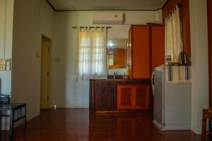 a kitchen with a refrigerator and a table at Sunee Seafood Bungalow in Ban Pak Klang