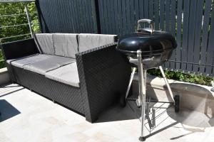 a charcoal grill sitting next to a couch on a patio at Refuge du Château avec terrace in Manom