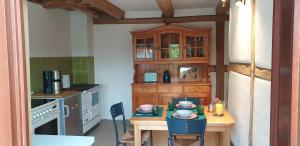 a small kitchen with a table and a wooden cabinet at Der kleine Fuchshof mit Hund, Pferd und Huhn in Rathlau