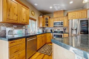 una cocina con armarios de madera y encimeras de granito en Northern Moose Lodge, en McCall
