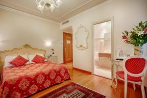 a bedroom with a bed and a table and a chair at Hotel San Luca Venezia in Venice