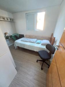 a bedroom with a bed and a chair and a window at Um quarto com banheiro privativo in Sao Paulo