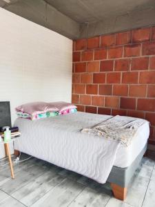 a bed in a room with a brick wall at Study by Los Molinos in Estación El Salto +12 photos