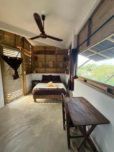 a bedroom with a bed and a table and a ceiling fan at Casa Gitana in Chamuscadero