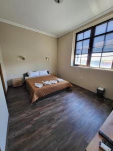 a bedroom with a bed and a large window at Balkan Aparts in Hisarya