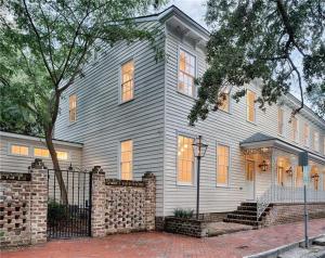 a gray house with a brick fence in front of it at Luxury Villa 3 BR w Private Bath Walk Everywhere in Savannah