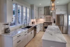 a large kitchen with white cabinets and a sink at Luxury Villa 3 BR w Private Bath Walk Everywhere in Savannah