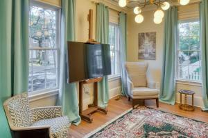 a living room with a tv and a chair and windows at Luxury Villa 3 BR w Private Bath Walk Everywhere in Savannah +52 photos