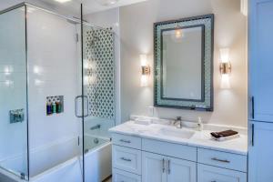 a bathroom with a shower and a sink and a mirror at Luxury Villa 3 BR w Private Bath Walk Everywhere in Savannah
