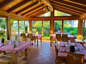 a restaurant with purple tables and chairs and windows at Haus Hörterer | Chiemgau Karte in Grassau +33 photos