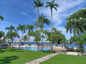 a resort with a swimming pool and palm trees at Dhauteya Villa in Amed