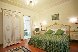 a bedroom with a bed with a green bedspread at Hotel San Luca Venezia in Venice