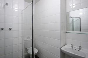 a white bathroom with a toilet and a sink at Vetho 2 Apartments OR Tambo Airport in Kempton Park +35 photos
