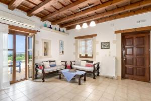 a living room with a couch and a table at Arodamos Villa with a pool, children's games, and BBQ, perfect for 23 people! in Skouloúfia