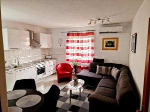 a living room with a couch and a kitchen at Drive & Stay Korčula in Korčula