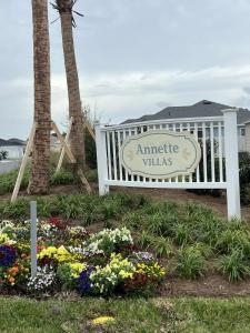 リーズバーグにあるBrand New 2-2 Villa with Golf Cartの花が飾られたアンティムヴィラの入り口の標識