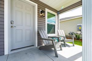 リーズバーグにあるBrand New 2-2 Villa with Golf Cartの玄関(椅子2脚、テーブル1台、ドア1台付)
