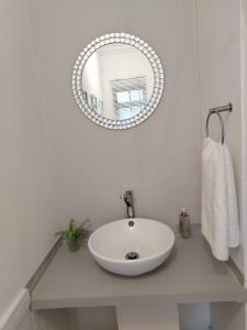 Un baño con un lavabo blanco y un espejo. en Faerie Glen B&B, en Pretoria