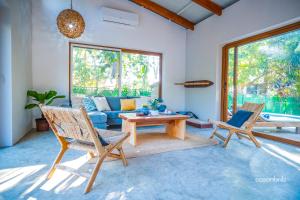 a living room with a blue couch and chairs at SantiChanti Walk to Sunzal Beach in Tamanique