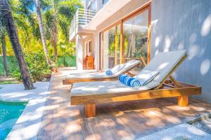 a pair of deck chairs sitting next to a swimming pool at SantiChanti Walk to Sunzal Beach in Tamanique