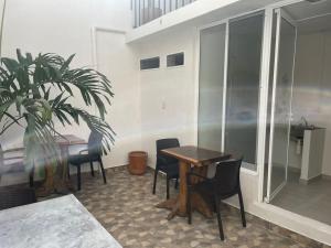a dining room with a table and chairs and a plant at Hotel Casa Chiapas in Tuxtla Gutiérrez