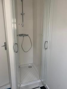 a shower with a clear glass shower stall in a bathroom at Petite Maison de Pêcheur in Mesquer +8 photos