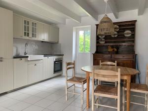 a kitchen with a wooden table and chairs at Petite Maison de Pêcheur in Mesquer